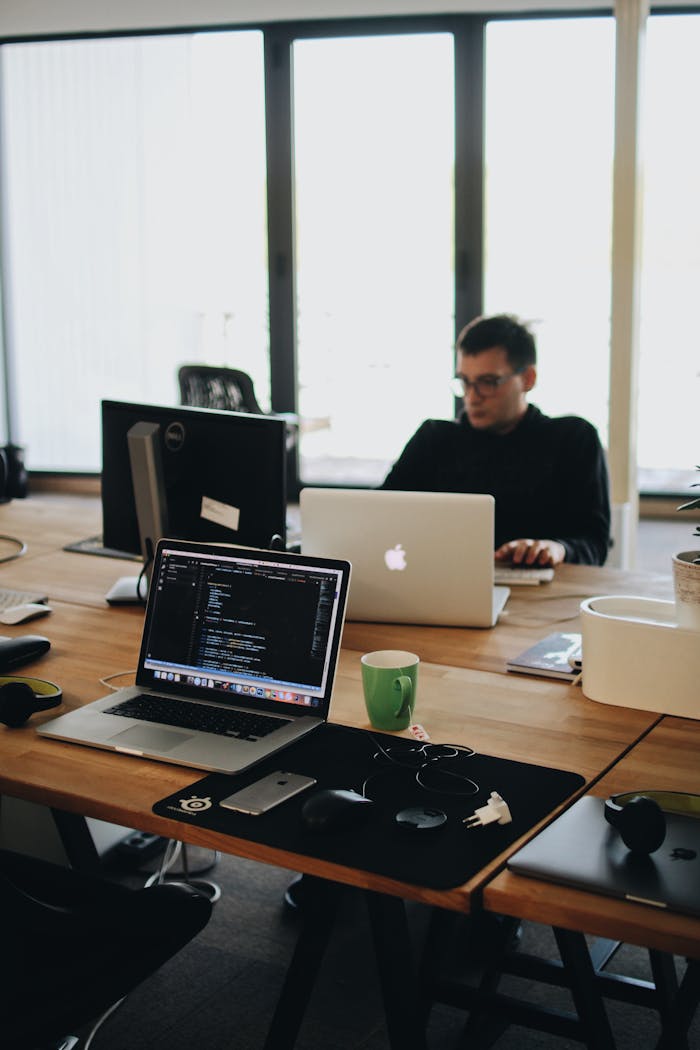 who-we-are A web developer working on code in a modern office setting with multiple devices.